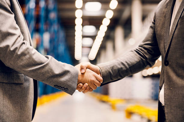 Business partners shaking hands in a warehouse